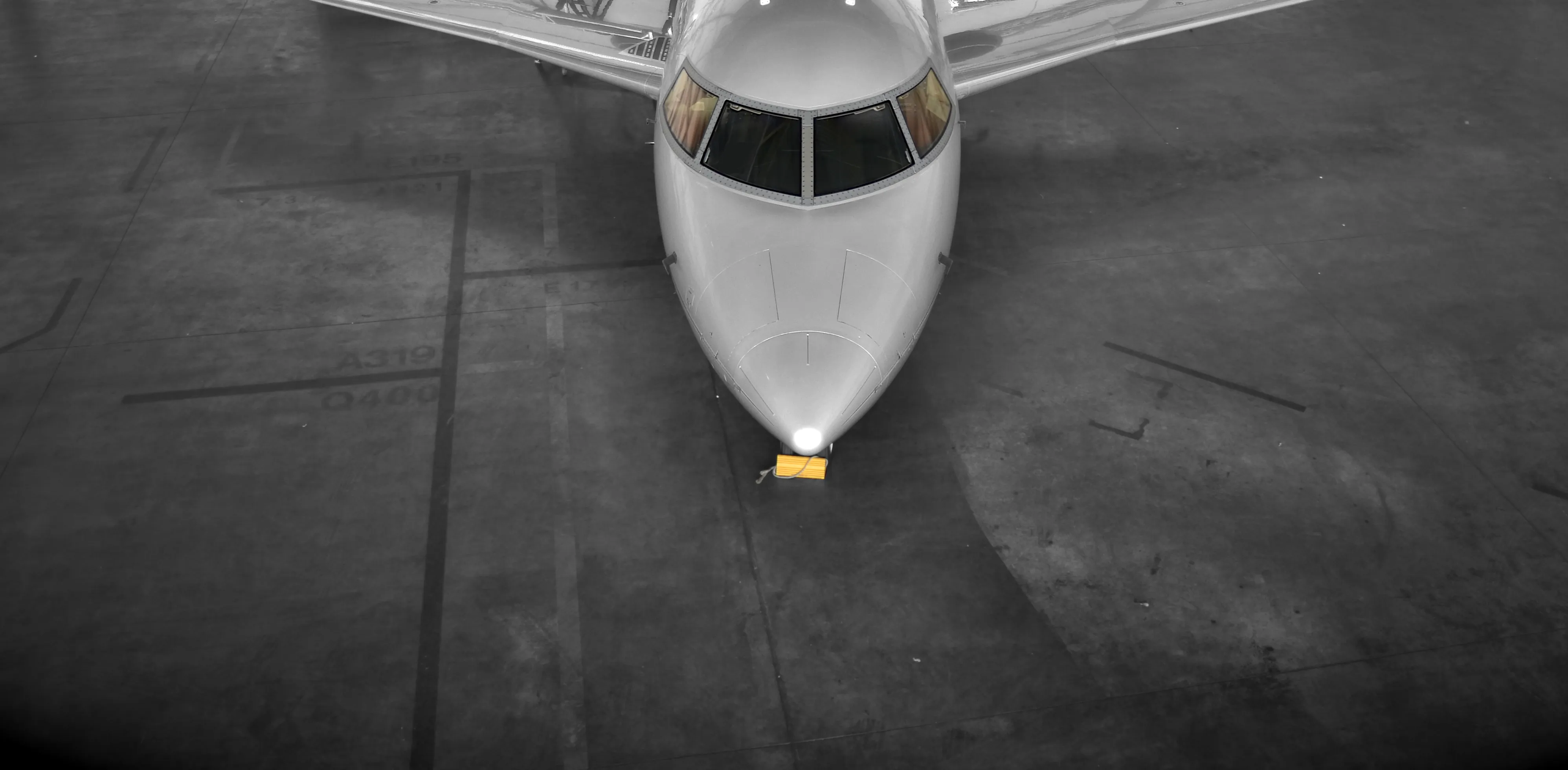 Business aircraft nose inside a maintenance hangar